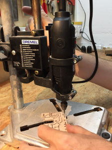 Drilling the PCB with a rotary drill mounted in a drill press jig. Don't even think about drilling free-hand with a thin carbide bit, they break like glass if bent. (click to enlarge)