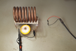 A big air core 2.05uH inductor and a high voltage ceramic 490pF capacitor being tested with the ring-down method. The square wave generator is connected to the loop and the oscilloscope is in parallel via a 10:1 probe (click to enlarge).