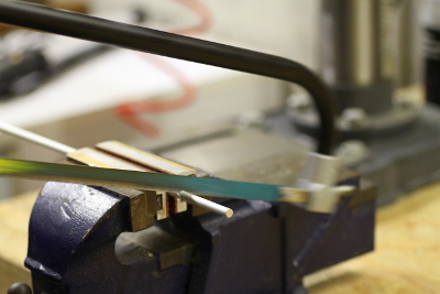 Cutting an aluminum rod with a hacksaw.