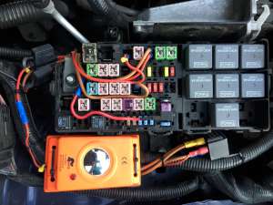 Picture of the modified battery junction box with the additional cigarette lighter relay and the rodent repeller (marked by the yellow ties). The battery charger plug is not visible in this picture as it's directly connected to the battery poles. (click to enlarge)